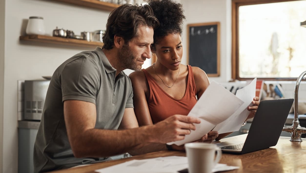 Mixed race couple looking at their finances in the kitchen
