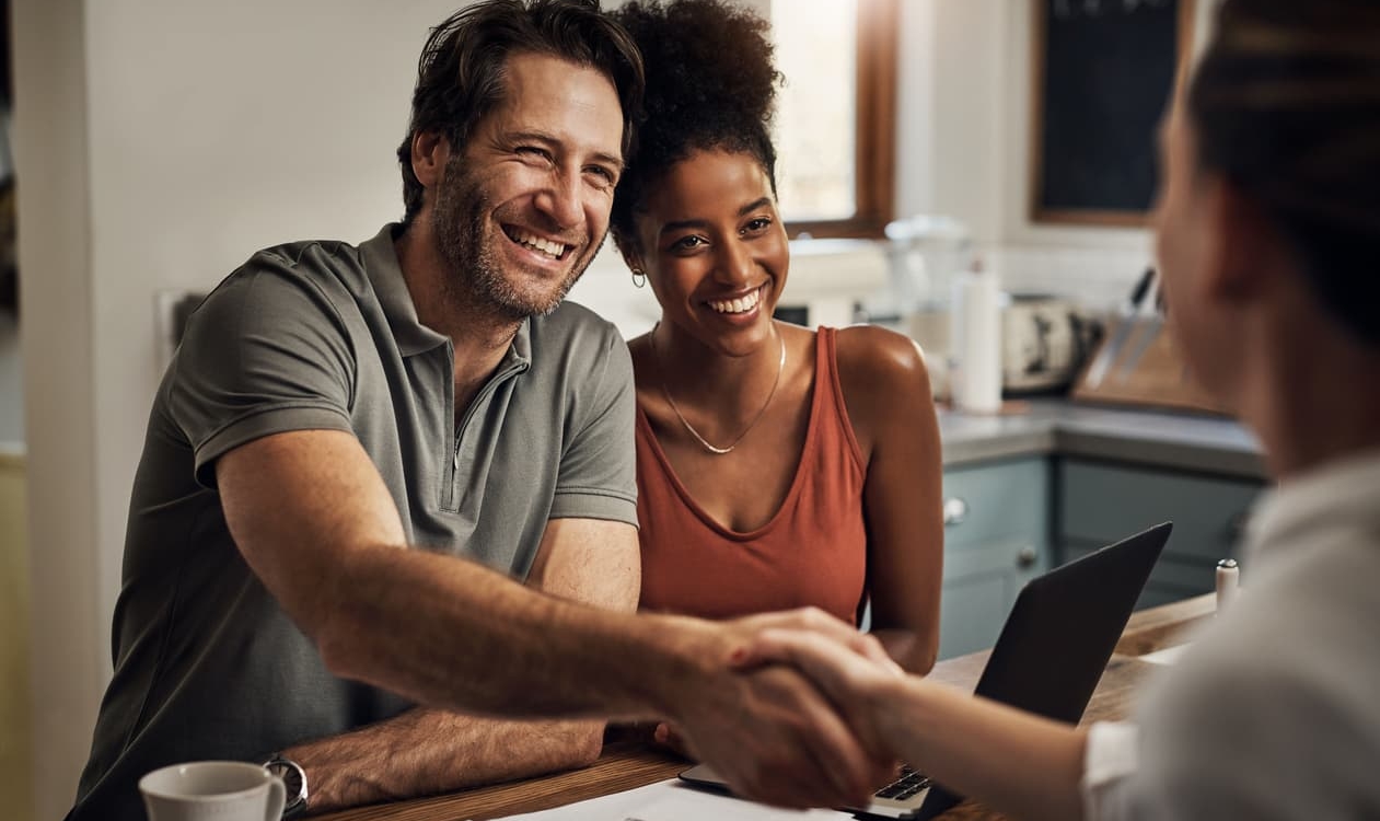 mixed race couple shaking hands with new financial advisors