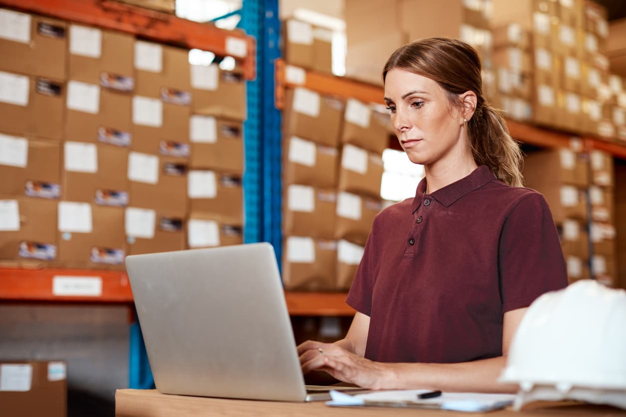 Business owner at her laptop in warehouse