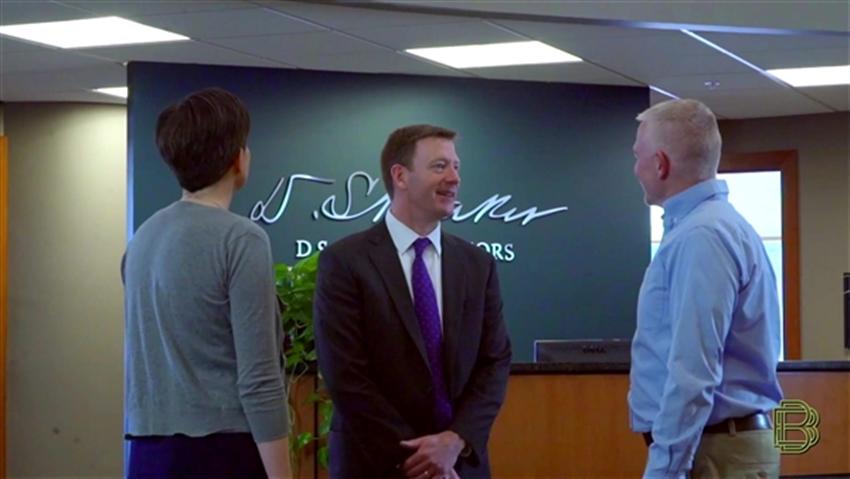 John Cunnison talking to two clients in bank lobby