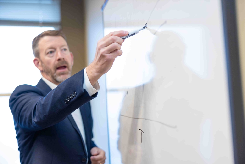 John Cunnison writing on a whiteboard
