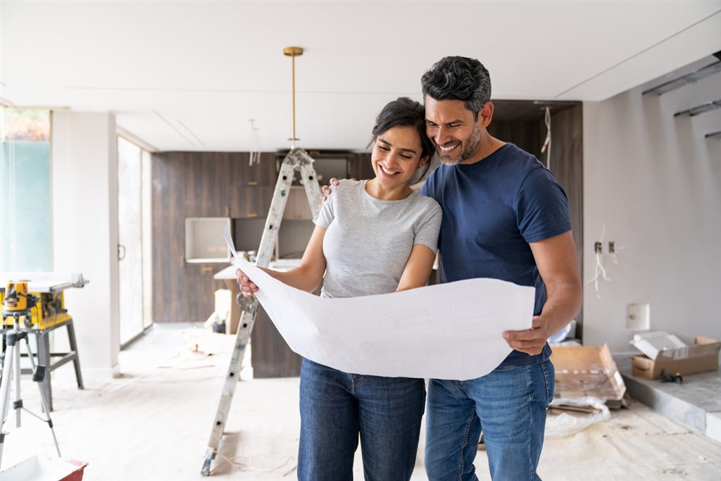 A couple looking over building plans in their new home