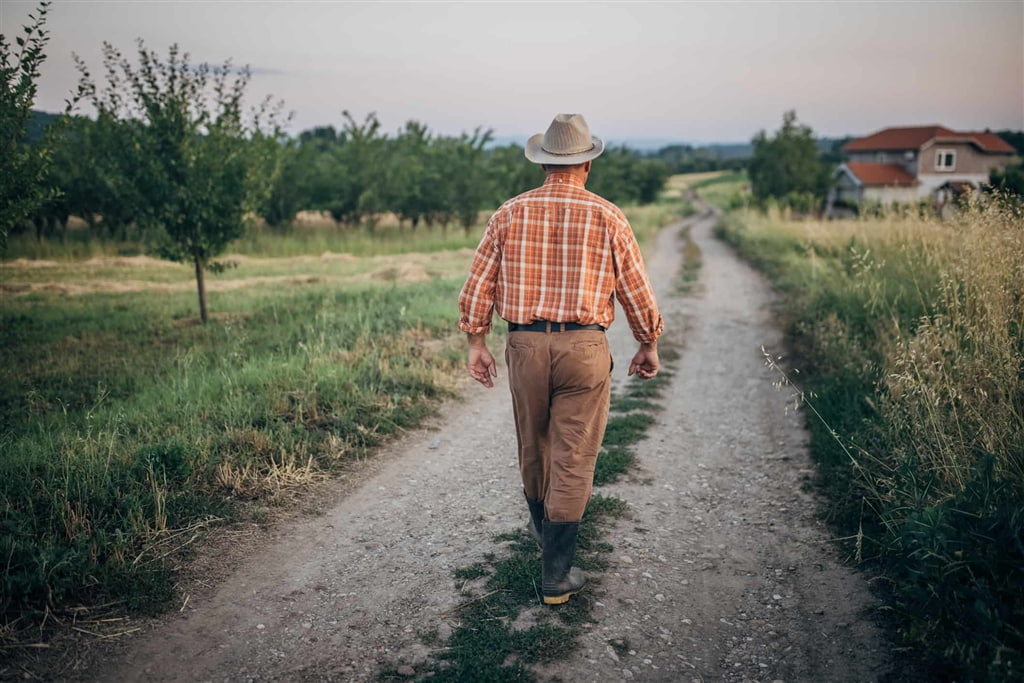 man walking through field