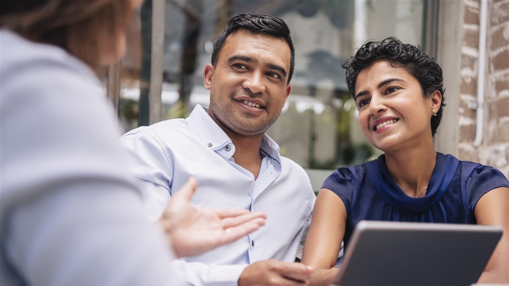 Latinx couple meeting with banker to discuss CDs