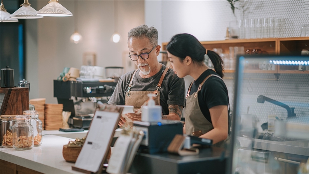 Chinese cafe owner with daughter at counter