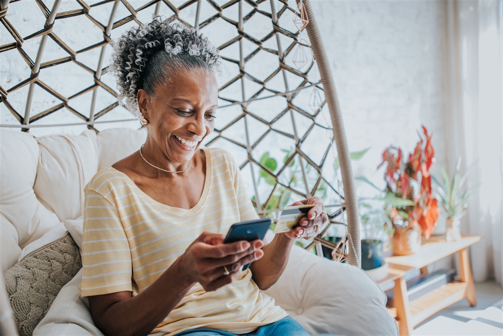 older woman with debit card smiling
