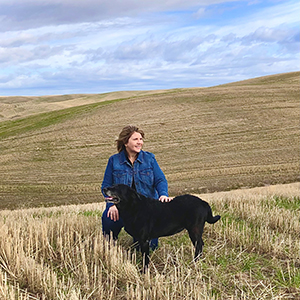 Cathy with her dog in a wheat field