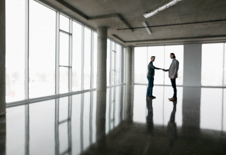 two business owners meeting in an empty warehouse