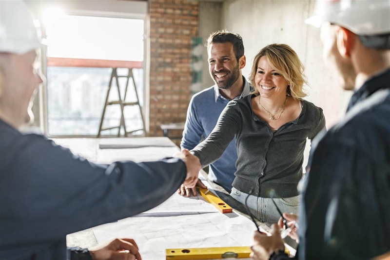 Female business owner shaking hand with contractor