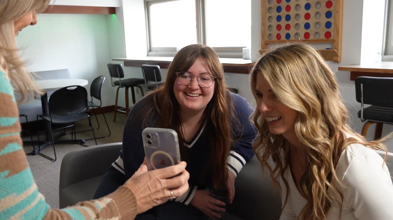 Two employees smiling in the break room