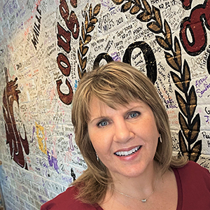 Cathy in front of a painted wall