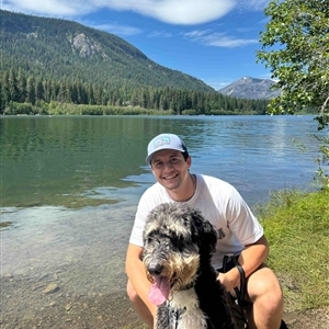 Picture of Tavin and his dog by a lake