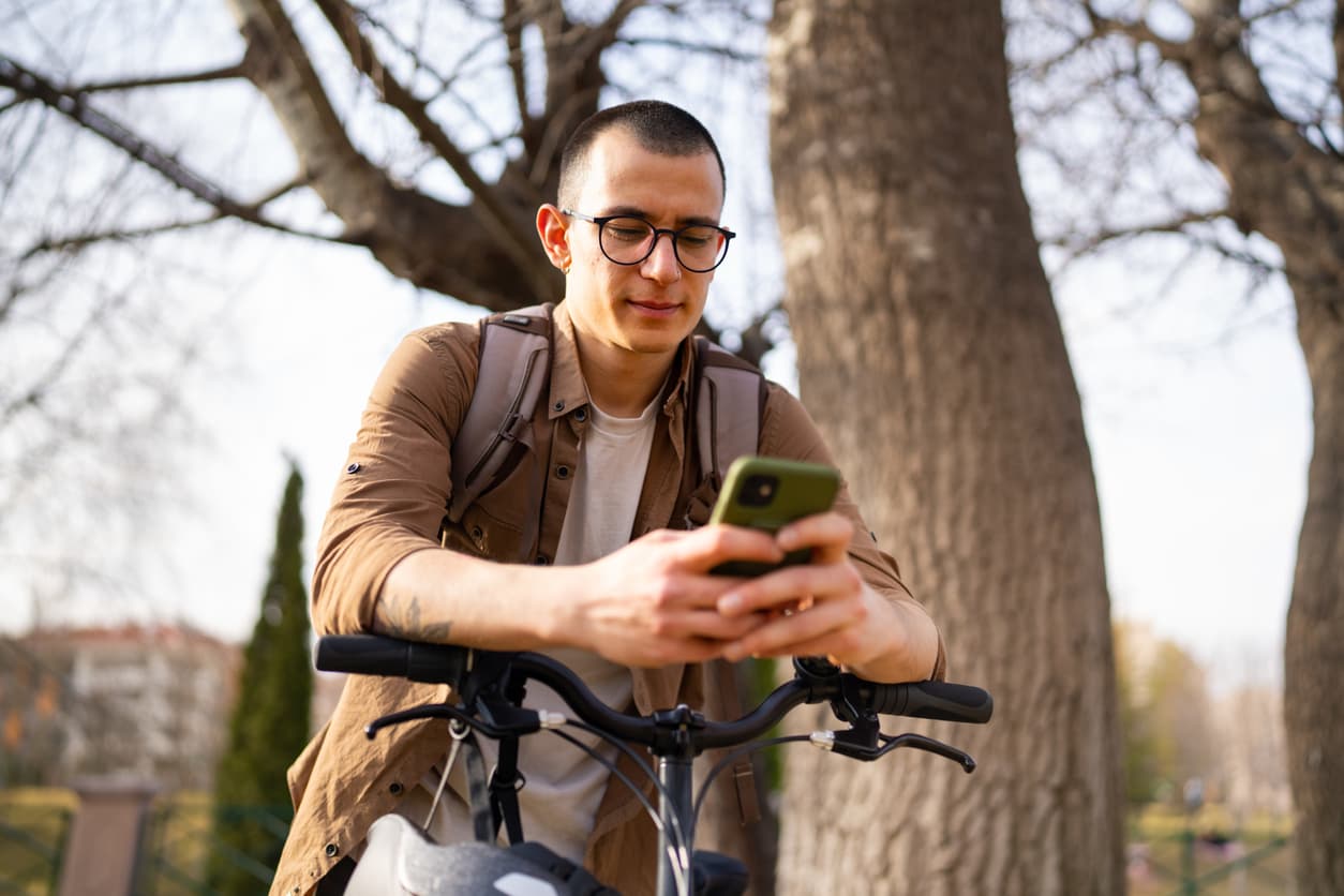 Man looking at his phone on a bike