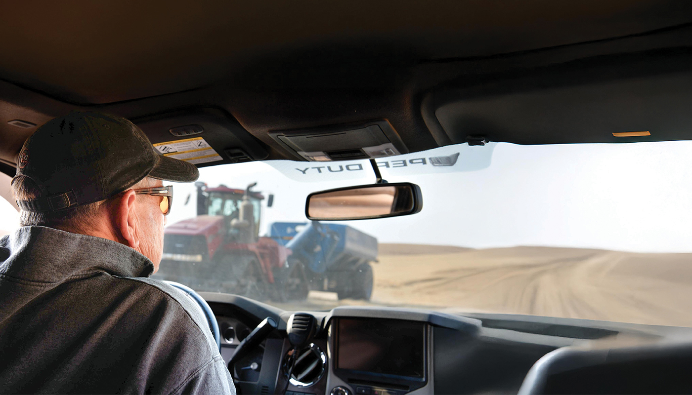 Farmer inside his truck working in wheat fields