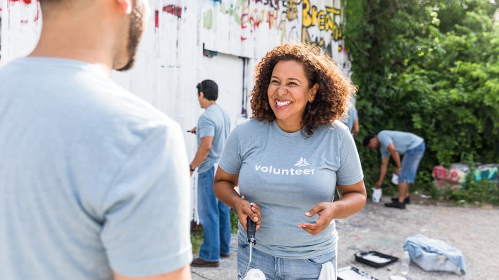 Picture of a woman volunteering by painting graffiti 